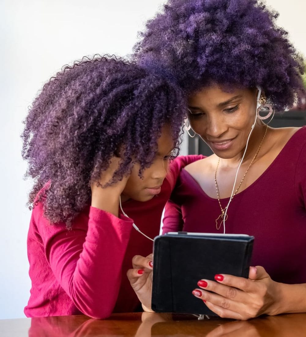 Mãe e filha usando o atendimento online da Diggi no tablet, juntas em casa